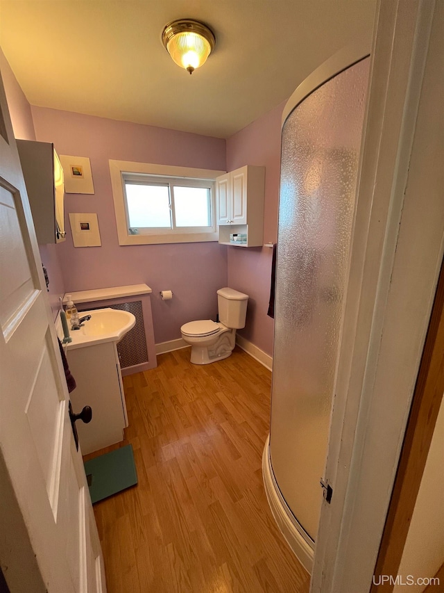 bathroom with walk in shower, vanity, toilet, and hardwood / wood-style flooring