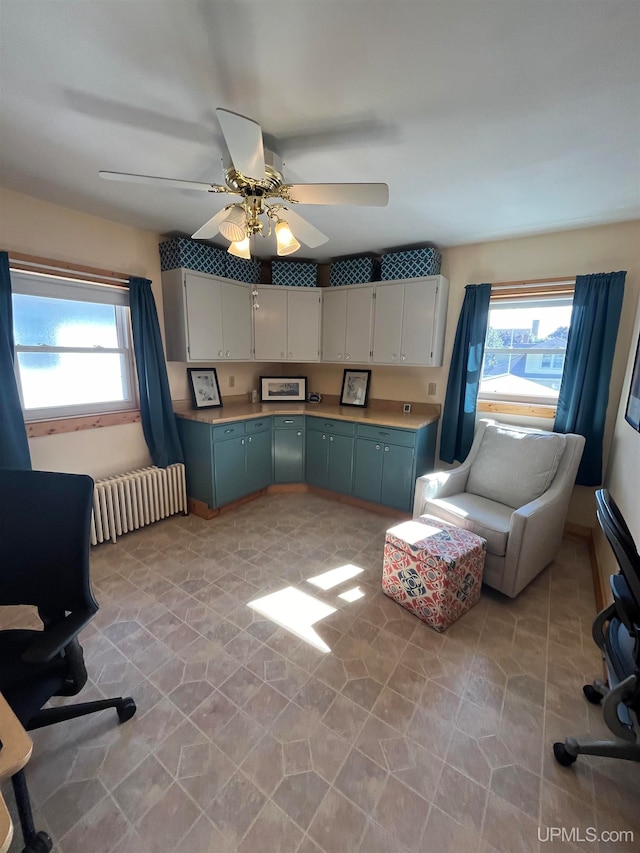 kitchen featuring radiator, ceiling fan, and a wealth of natural light