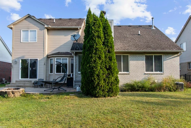 rear view of property featuring a patio, a yard, and central AC unit