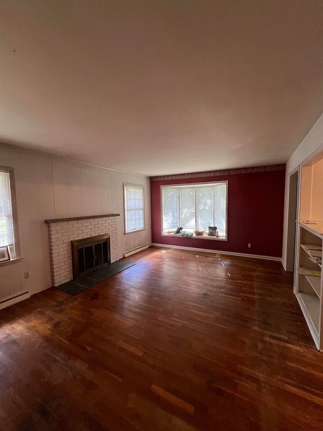 unfurnished living room featuring a fireplace, dark wood-type flooring, and a wealth of natural light