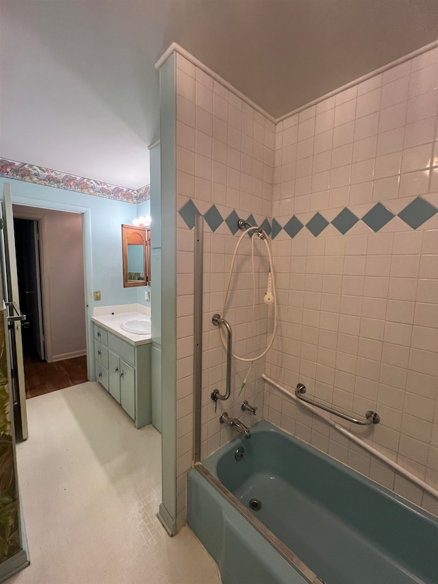 bathroom with tiled shower / bath and vanity