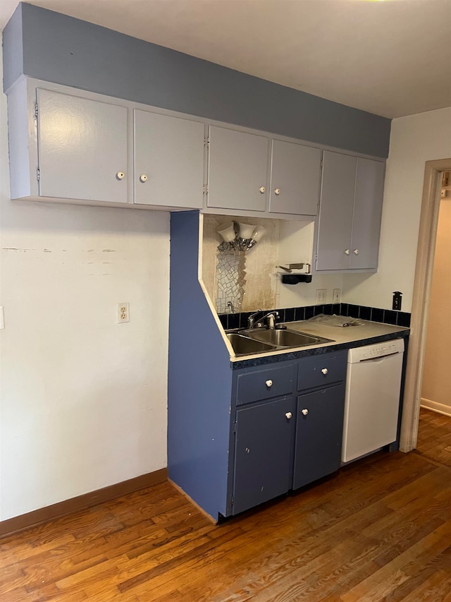 kitchen with hardwood / wood-style floors, backsplash, dishwasher, and sink