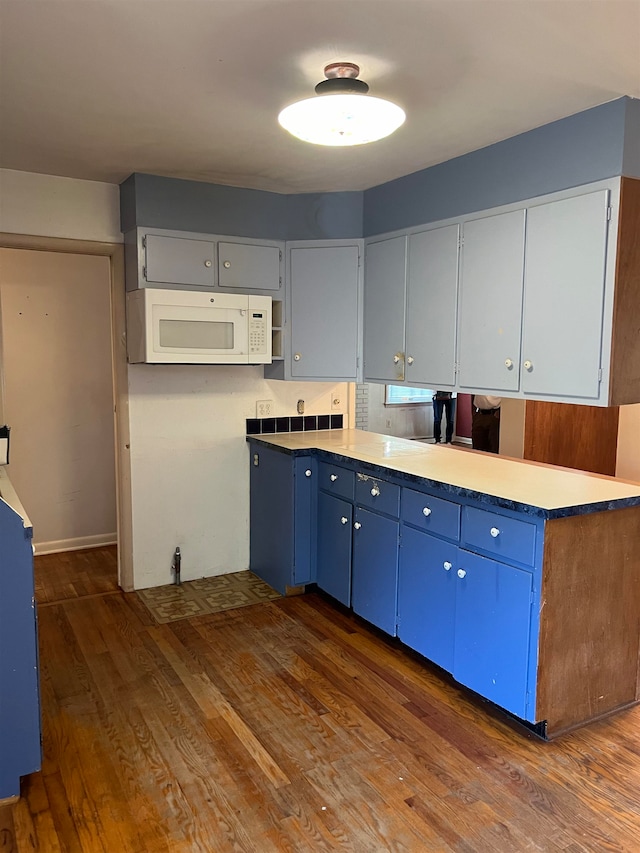 kitchen with blue cabinetry and dark wood-type flooring