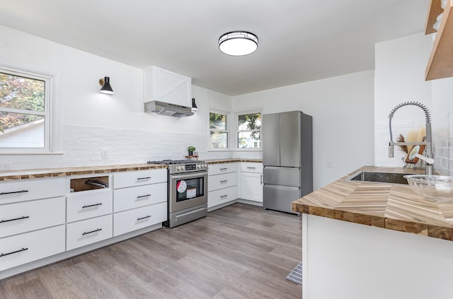 kitchen featuring white cabinets, stainless steel appliances, plenty of natural light, and sink