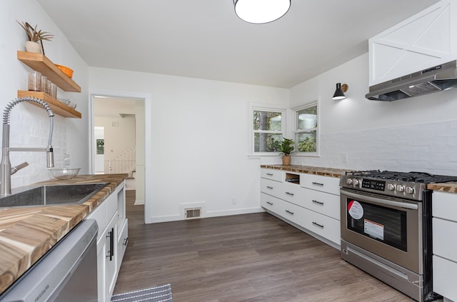 kitchen with stainless steel appliances, white cabinetry, dark wood-type flooring, and sink