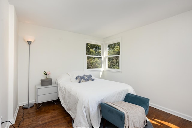 bedroom with dark hardwood / wood-style flooring