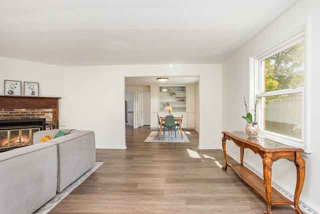 living room with a fireplace, a baseboard radiator, and hardwood / wood-style flooring