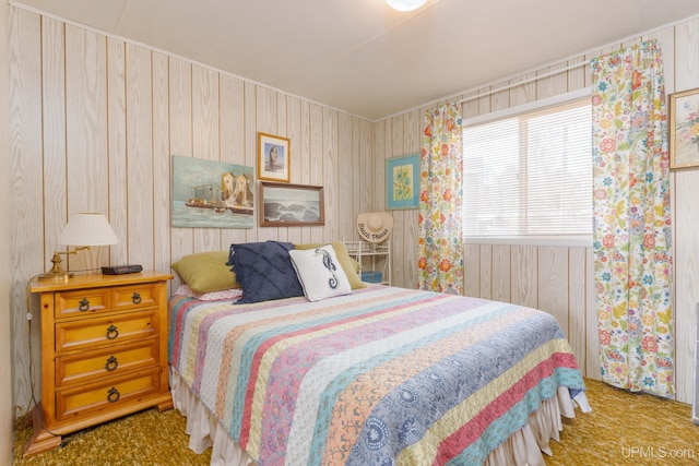 carpeted bedroom featuring wood walls