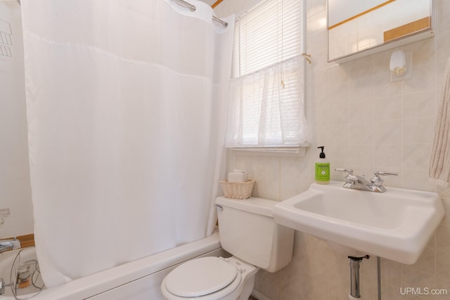 full bathroom featuring tile walls, shower / bath combo, toilet, and sink