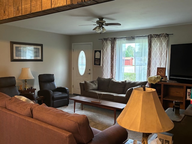 carpeted living room with ceiling fan