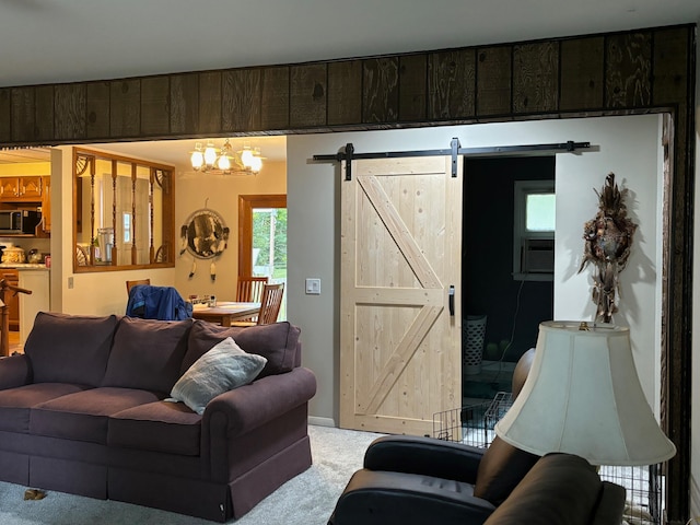 living room featuring a barn door, carpet floors, and an inviting chandelier