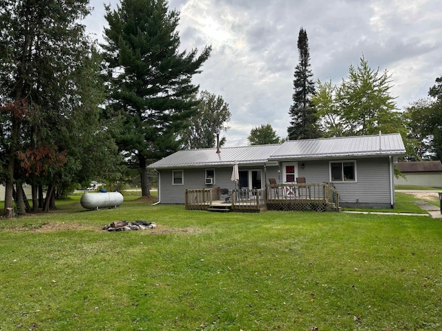 back of property featuring a deck and a yard