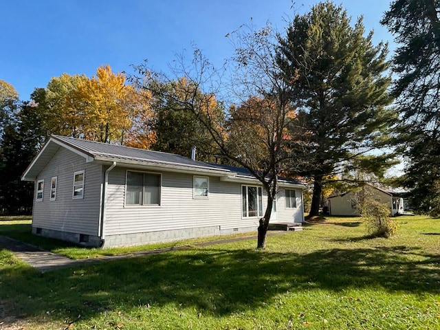 view of side of home with a yard