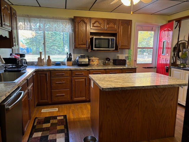 kitchen featuring dark wood-type flooring, ceiling fan, appliances with stainless steel finishes, and a kitchen island