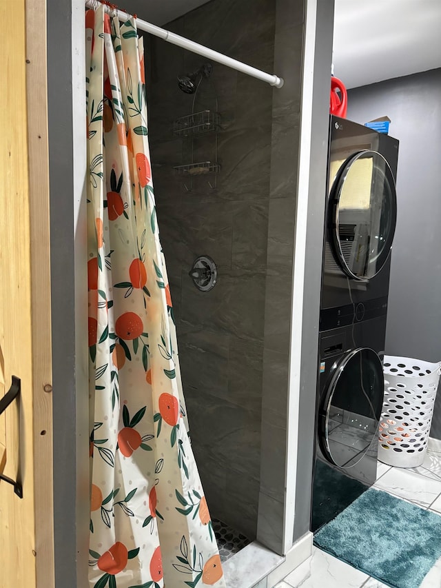 bathroom featuring stacked washing maching and dryer and walk in shower