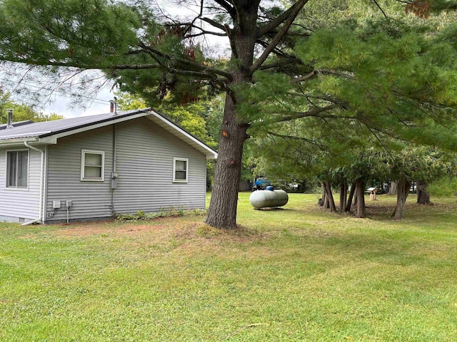 view of side of home with a yard