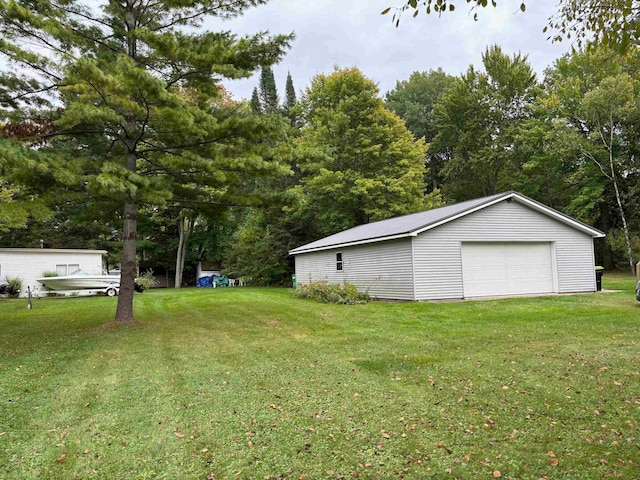 view of yard with a garage and an outbuilding