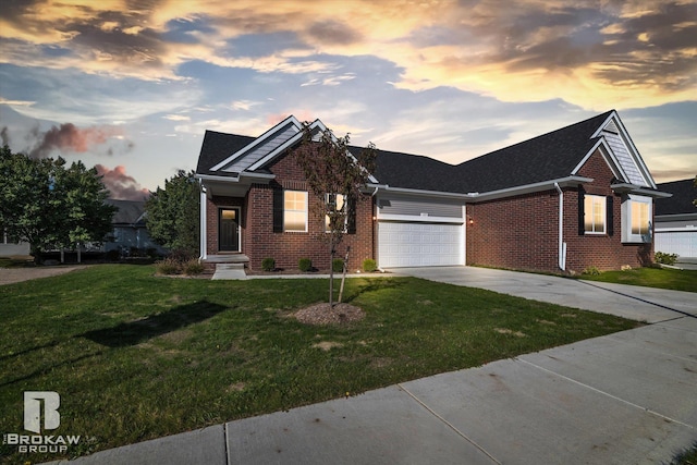 view of front of house featuring a garage, brick siding, driveway, and a front lawn