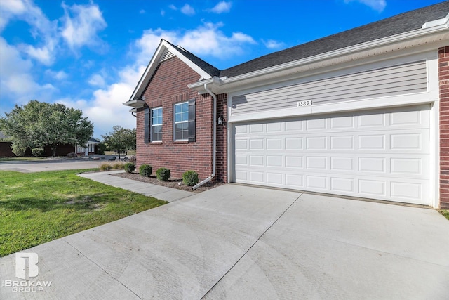 view of property exterior with a yard, brick siding, driveway, and a garage