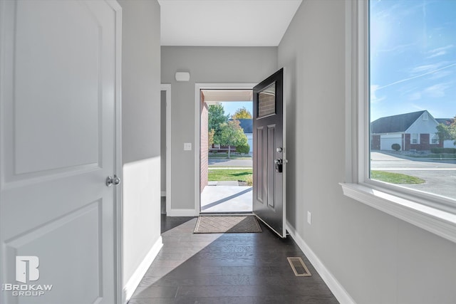 entrance foyer with dark wood-style floors, visible vents, and baseboards