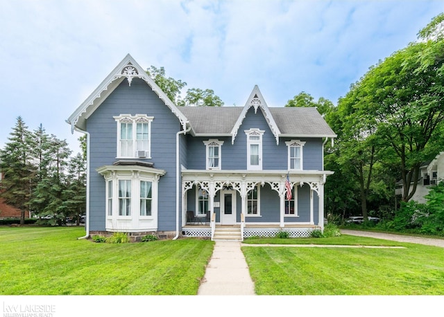 victorian house featuring a front lawn and covered porch