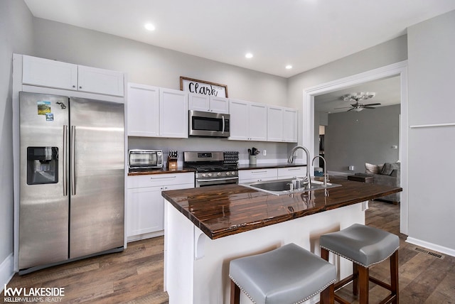 kitchen featuring white cabinets, sink, stainless steel appliances, and a breakfast bar