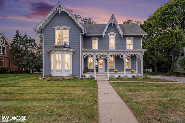 victorian home with a porch and a yard