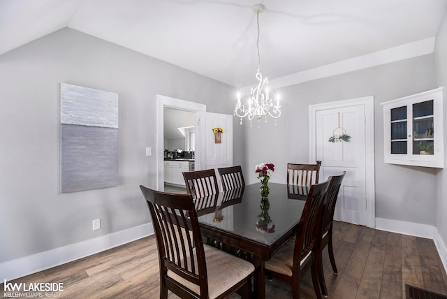 dining room featuring lofted ceiling, a chandelier, and light hardwood / wood-style floors