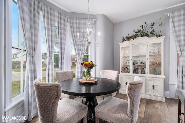 dining area featuring dark hardwood / wood-style floors and an inviting chandelier