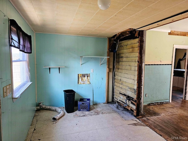 laundry room with wood-type flooring and wood walls