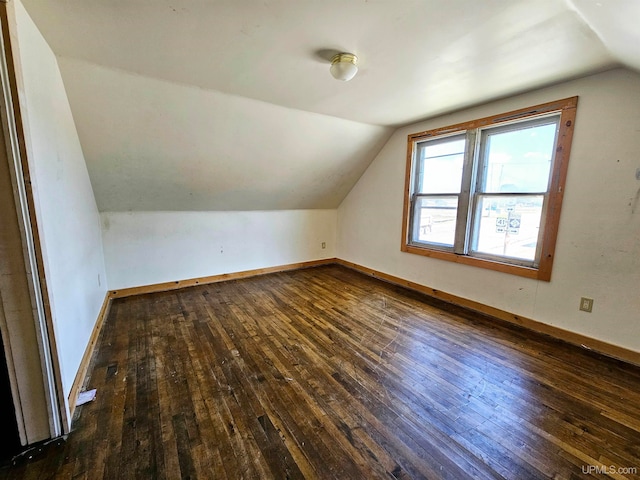 additional living space featuring lofted ceiling and dark hardwood / wood-style flooring