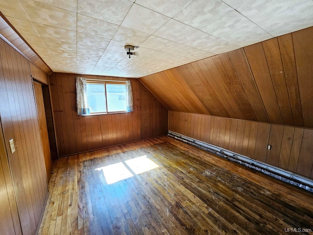 bonus room with hardwood / wood-style flooring, lofted ceiling, and wooden walls