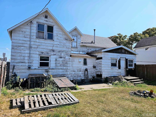 rear view of property featuring a lawn