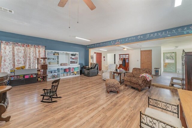 living room featuring light hardwood / wood-style flooring and ceiling fan