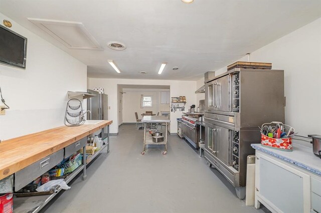 kitchen with concrete flooring and wooden counters