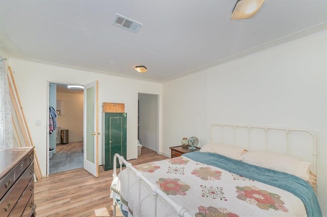 bedroom featuring light wood-type flooring and crown molding