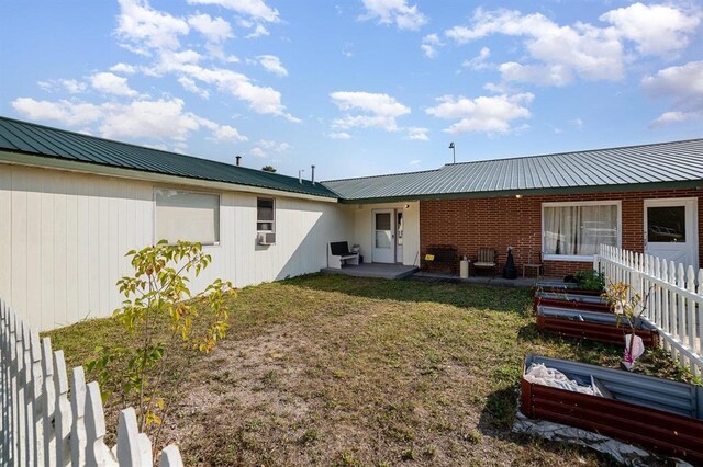 back of property with a lawn and a patio