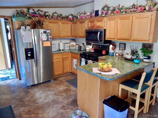 kitchen featuring kitchen peninsula, appliances with stainless steel finishes, and a textured ceiling