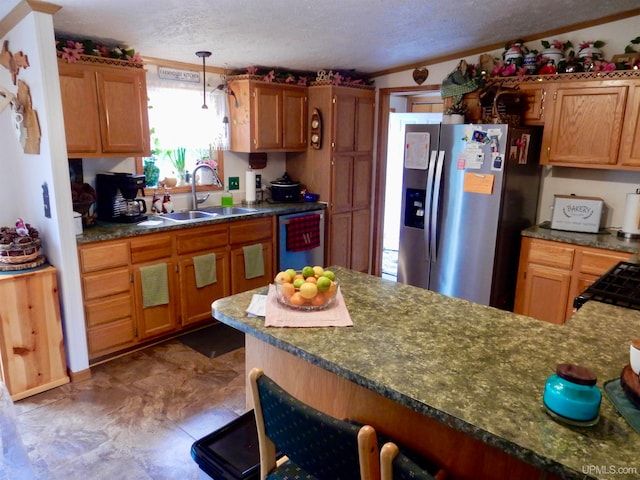 kitchen with appliances with stainless steel finishes, a textured ceiling, sink, and decorative light fixtures