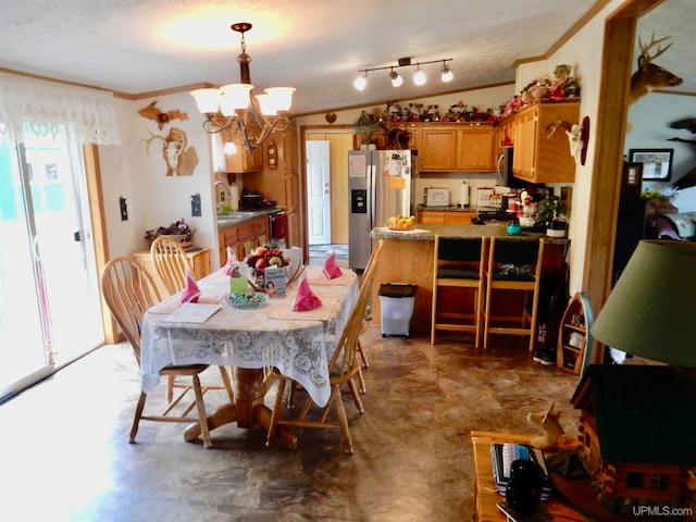 dining room with ornamental molding, a chandelier, and sink