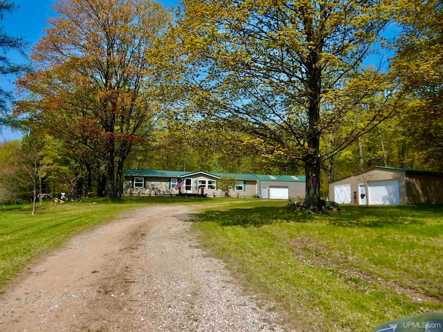 view of front of home featuring a front lawn, an outdoor structure, and a garage