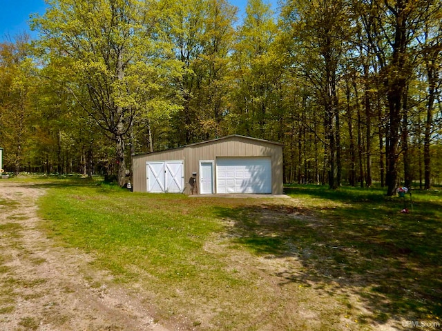 view of outdoor structure with a lawn and a garage