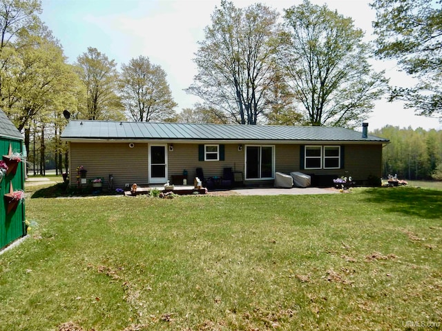 rear view of house with a lawn and a patio area