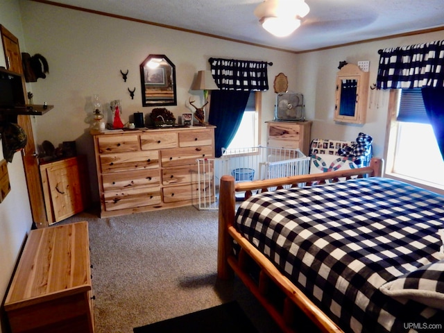 carpeted bedroom featuring ornamental molding and a textured ceiling