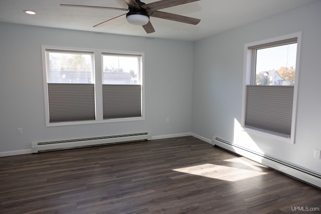 spare room featuring a baseboard radiator, a wealth of natural light, and dark hardwood / wood-style floors