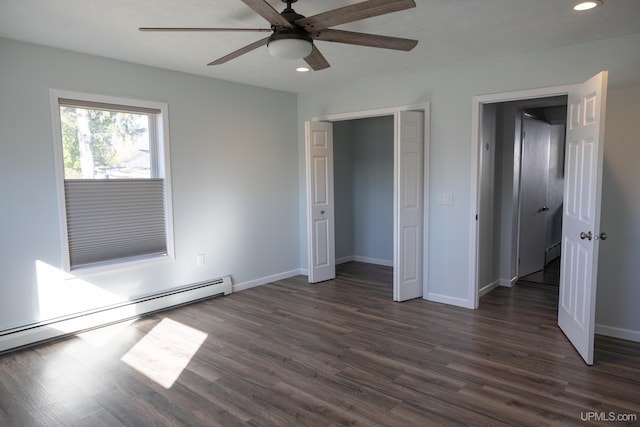 unfurnished bedroom featuring ceiling fan, baseboard heating, dark hardwood / wood-style floors, and a closet