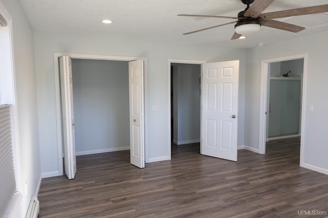 unfurnished bedroom with a baseboard heating unit, dark wood-type flooring, ceiling fan, and a closet