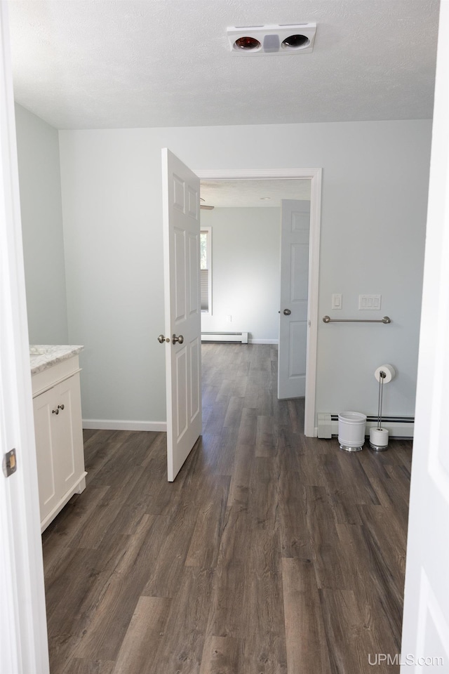 bathroom featuring vanity, a baseboard radiator, hardwood / wood-style floors, and a textured ceiling