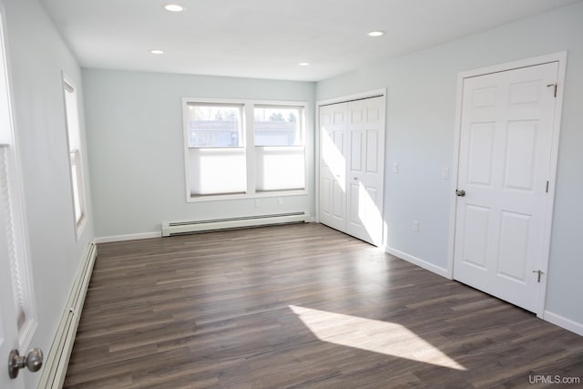 unfurnished bedroom featuring dark hardwood / wood-style floors and a baseboard heating unit