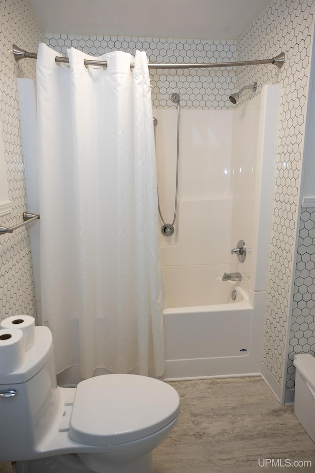 bathroom with shower / tub combo, hardwood / wood-style floors, and toilet